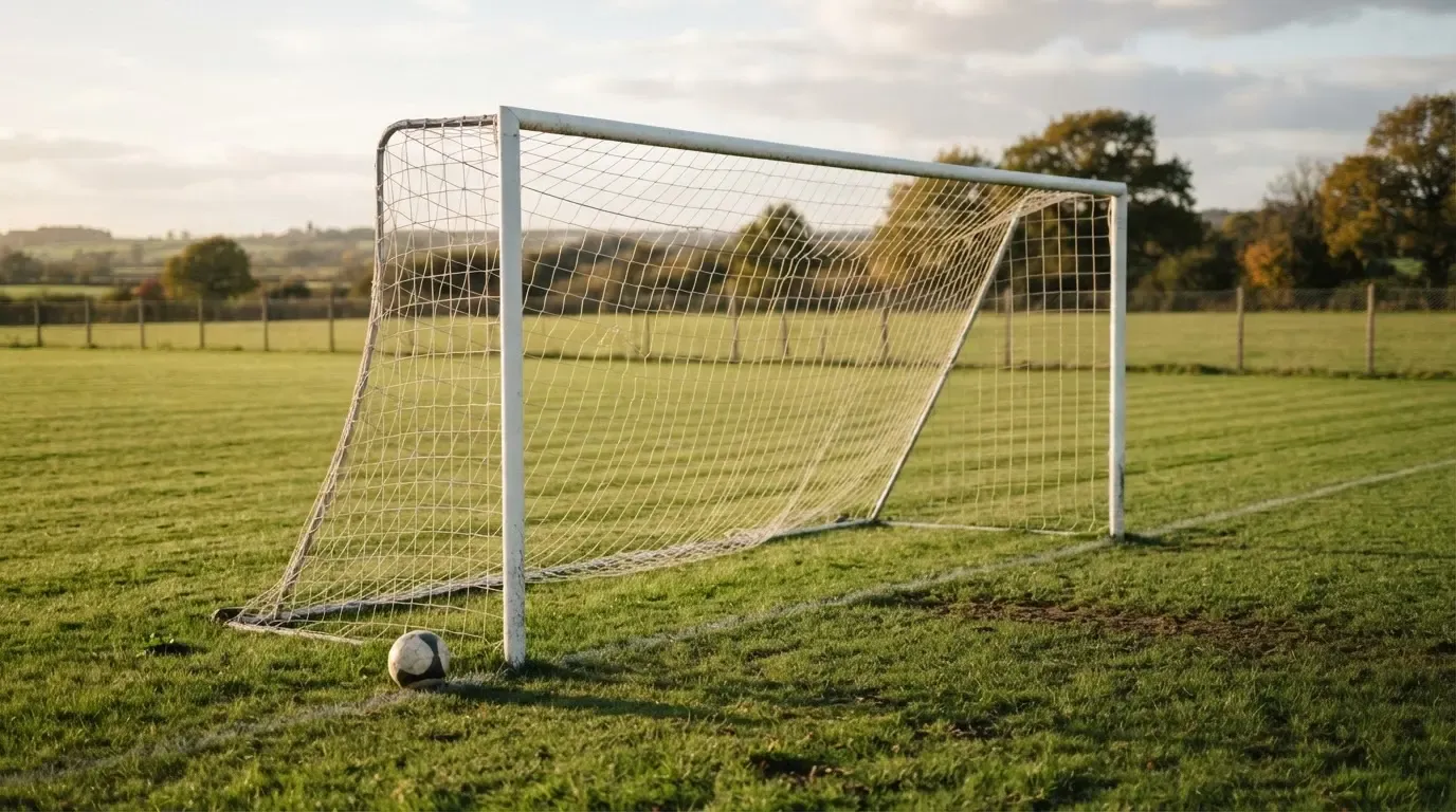Ein Fussballtor mit locker hängendem Netz auf einem Trainingsplatz, das sich leicht im Wind bewegt.